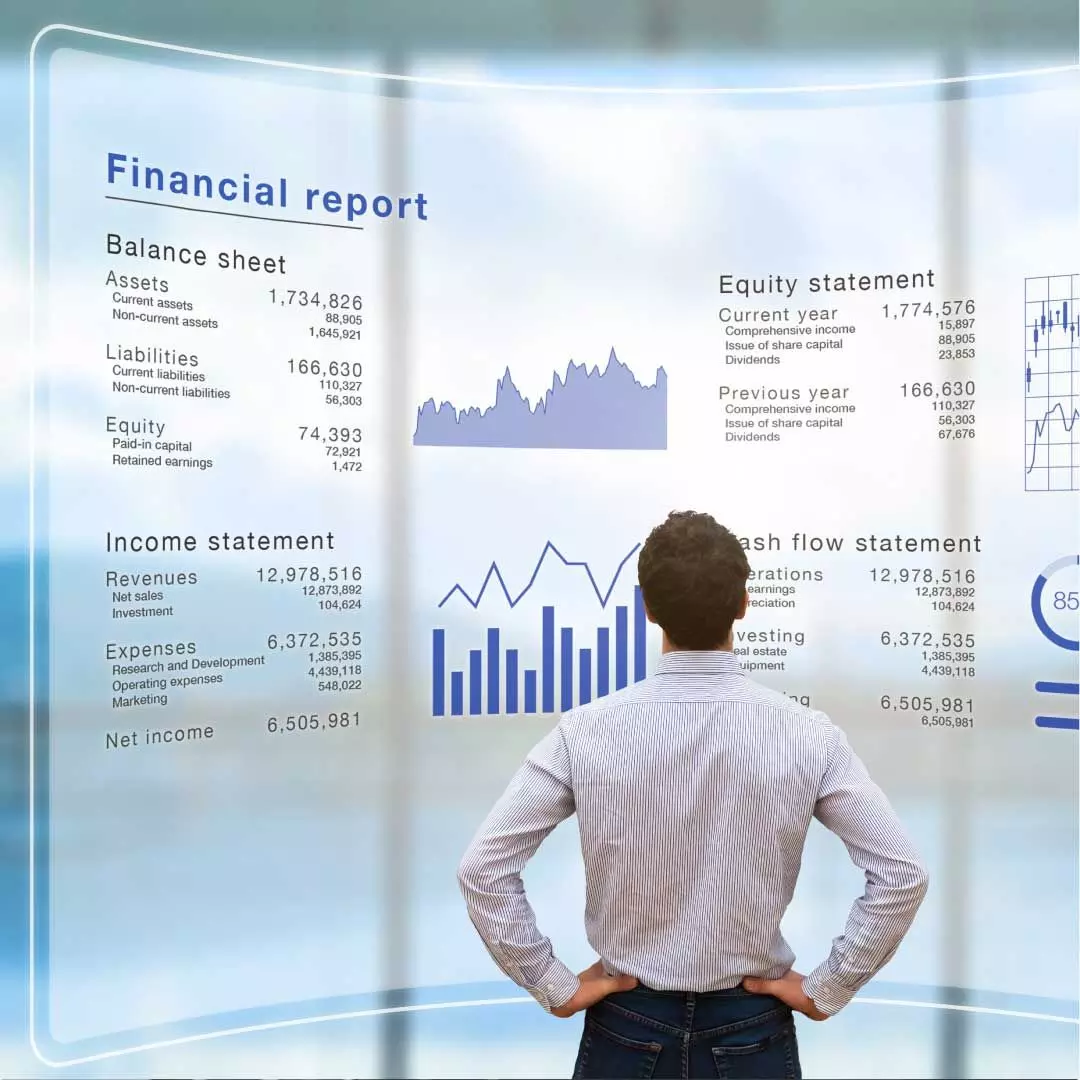A man stands in front of a large semi-transparent display showcasing various types of financial data.